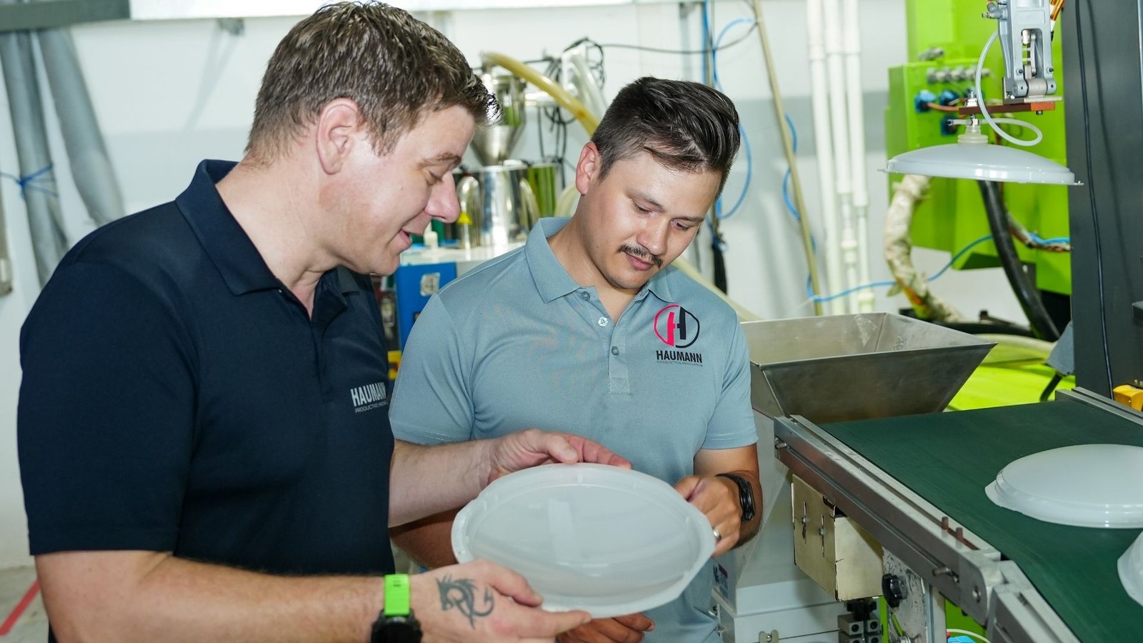 Haumann team performing quality check on injection molded plastic components in a manufacturing