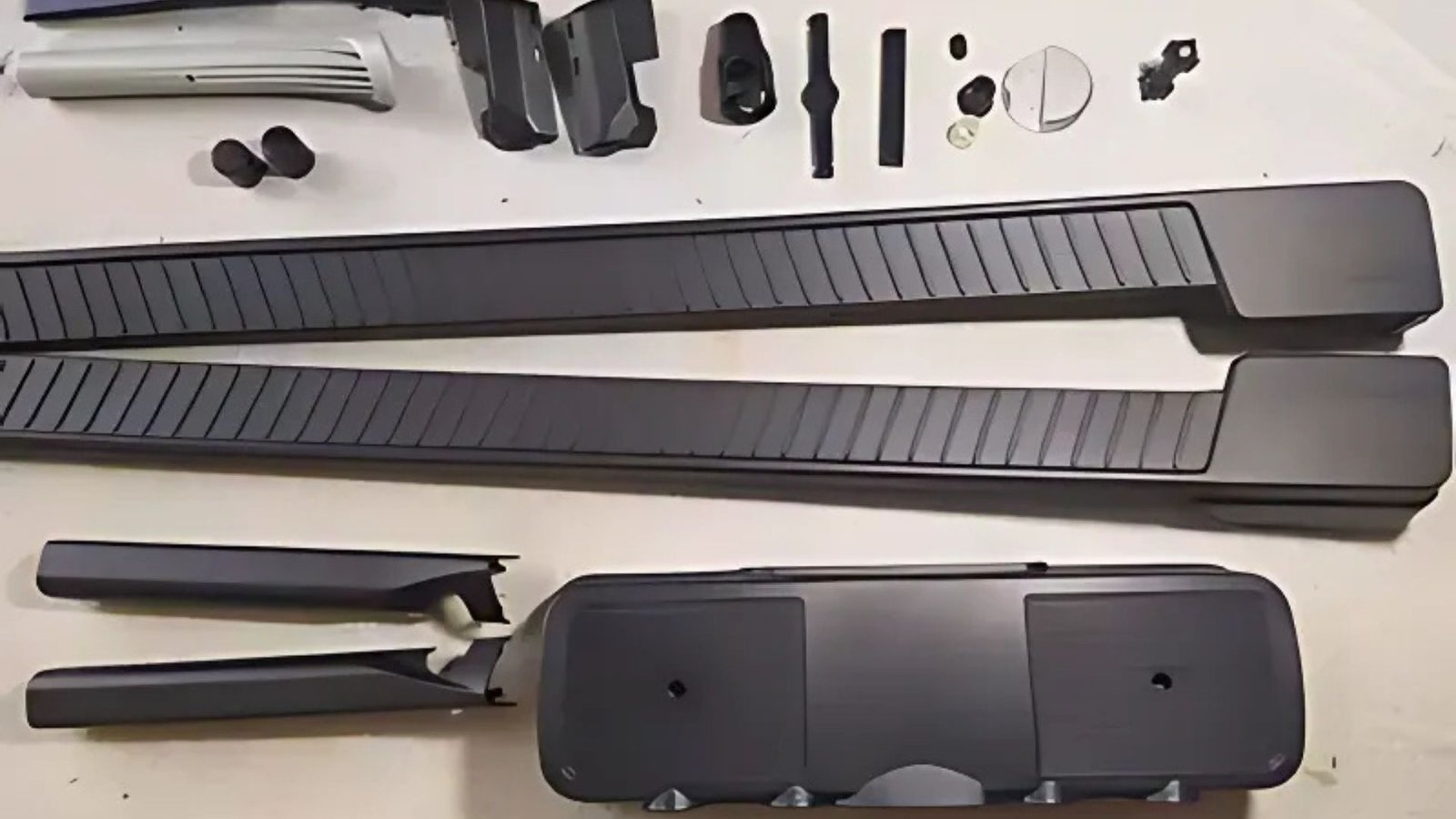 Injection molded parts for gym equipment including ergonomic grips, structural frames, and high-durability training components
