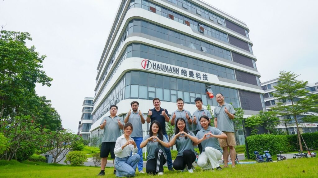 Haumann Technology team standing in front of company headquarters representing global manufacturing excellence