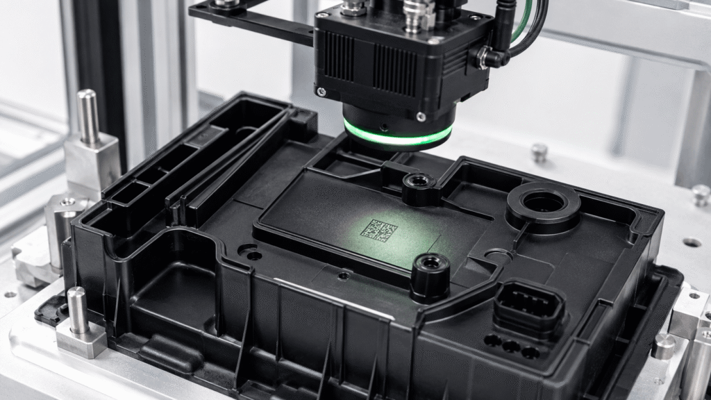 Industrial scanner reading a DataMatrix marking on an injection-molded automotive battery component