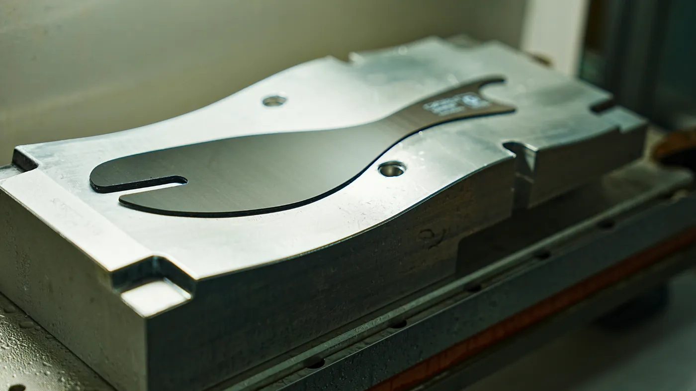 Steel injection mould tool with a formed carbon fibre plate for performance footwear